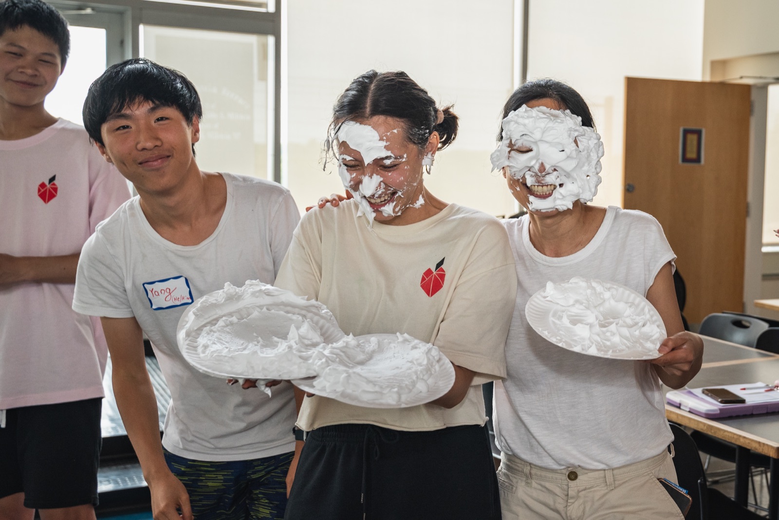 Yang laughing with fellow Apex for Youth mentors covered in shaving cream pies at the Closing Day Ceremony